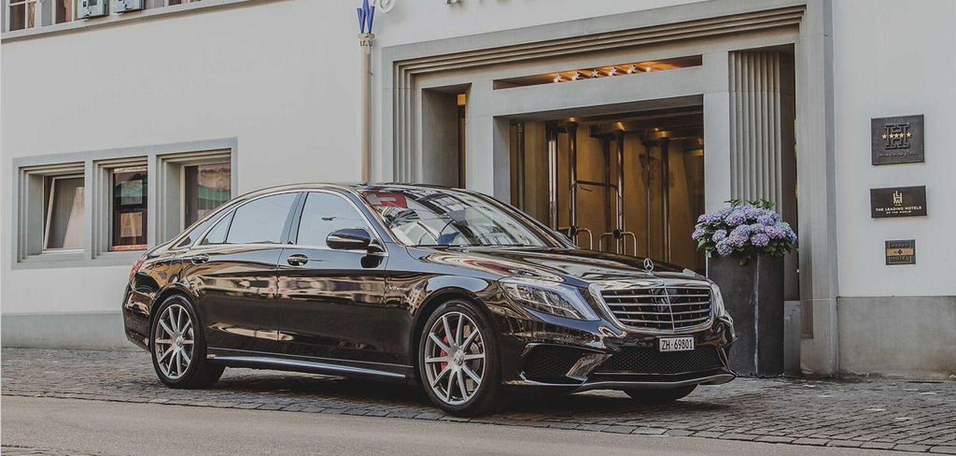 Mercedes-Benz limousine parked outside a hotel entrance